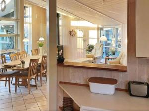 a kitchen with a table and a dining room at Summerhouse On The Beach And With Ocean View in Yderby +9 photos