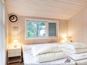 a bedroom with two white pillows and a window at Summerhouse On The Beach And With Ocean View in Yderby