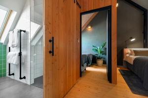 a bathroom with a glass door leading to a bedroom at Lennepserf - De Hoeven in Veessen