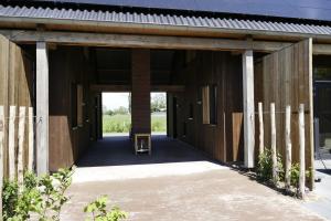 a wooden barn with a door leading into it at Lennepserf - De Hoeven in Veessen