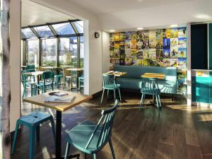 a restaurant with blue chairs and tables and windows at hotelF1 Nancy Sud in Houdemont