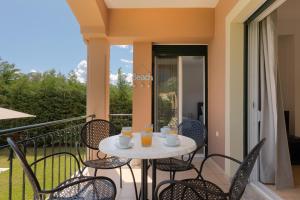 a table and chairs on a balcony with a view at Villa Renata -Pool, Large Garden & Free Parking, 2 Minutes Walk from The Beach in Barbati