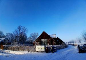 a barn in the snow with a fence at Lennepserf - De Achterhoek in Veessen