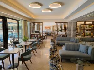 a hotel lobby with couches and tables and chairs at JOHN & GEORGE in Tolo