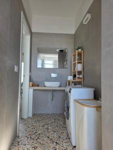 a bathroom with a sink and a washing machine at A 34 passi dal mare in Torre Ovo
