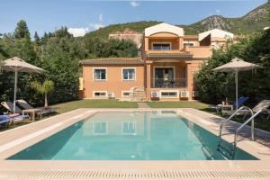 a villa with a swimming pool in front of a house at Villa Renata -Pool, Large Garden & Free Parking, 2 Minutes Walk from The Beach in Barbati