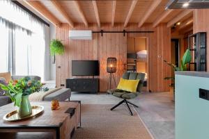 a living room with a couch and a tv at Lennepserf - De Horstjes in Veessen