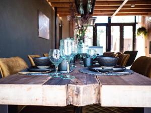 a wooden table with wine glasses on top of it at Lennepserf - De Horstjes in Veessen
