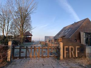 a wooden gate to a barn with a fence at Lennepserf - De Horstjes in Veessen