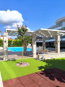 a patio with a tree and a pool at Luxury Suite Gala in Nikiti