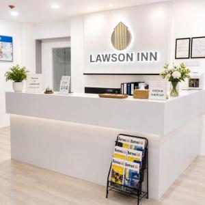 a white counter with a sign in a store at Lawson Inn in Sibu
