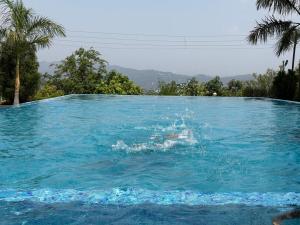 a person is splashing in a swimming pool at Countryside Retreat in Pune