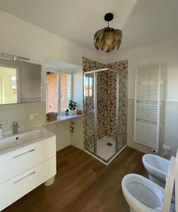 a bathroom with a shower with a sink and a mirror at La terrazza sul Ricetto - Appartamento Suite in Candelo +13 photos