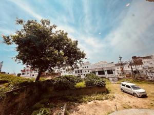 a white car parked in front of a building at ramraz residency in Ayodhya