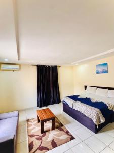 a bedroom with a king sized bed and a couch at Sea-Point Homes in Maiyegun