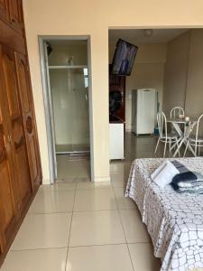 a bedroom with a bed and a kitchen with a table at Suítes São Lourenço in São Lourenço
