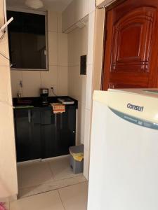 a small kitchen with a sink and a door at Suítes São Lourenço in São Lourenço