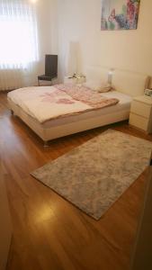ein Schlafzimmer mit einem Bett und einem Teppich auf dem Boden in der Unterkunft Messezimmer Hannover Langenhagen - room agency in Hannover