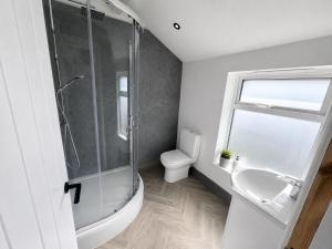 a bathroom with a shower and a toilet and a sink at The Carlton Collection in Birkenhead +28 photos