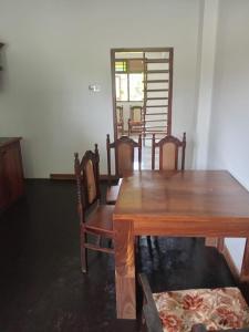 a dining room with a wooden table and chairs at Kurana Resident in Katunayaka