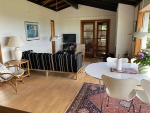 a living room with a couch and a table and chairs at Veddinge Odsherreddenmark - House With Seaview in Asnæs