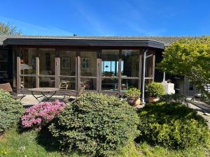 a screened in porch of a house with plants at Veddinge Odsherreddenmark - House With Seaview in Asnæs