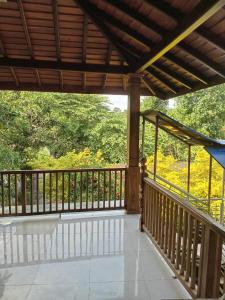 a porch with a wooden railing and a view of trees at Kurana Resident in Katunayaka +8 photos