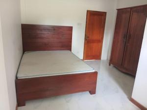 a bedroom with a bed and two wooden cabinets at Kurana Resident in Katunayaka