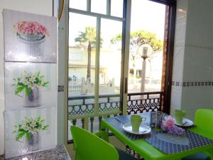 einen Balkon mit einem Tisch und einem Fenster mit Blumen in der Unterkunft Bicos 101 by Check-in Portugal in Albufeira