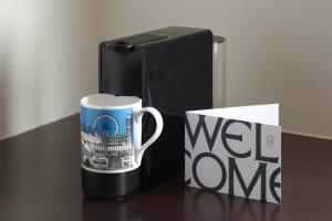 a coffee mug and a wet one mug next to a refrigerator at Guild Hotel Marble Arch in London