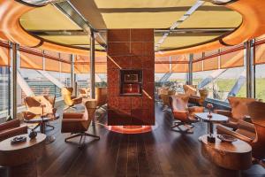 a restaurant with a fireplace in a room with windows at The Emory, Maybourne in London