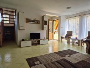 a living room with a flat screen tv and a couch at Csendliget kulcsosház in Sub Cetate