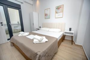 a bedroom with a bed with towels on it at Euphoria Central Living in Stavros