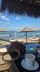 a table with a cup of coffee and a view of the beach at Eni's Villa in Lezhë
