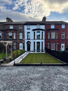 a large brick house with a lawn in front of it at The Carlton Collection in Birkenhead