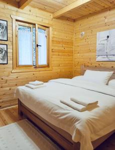 a bedroom with two beds in a wooden cabin at Holiday house Flores near Kolasin in Kolašin