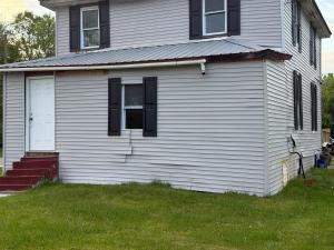 a white house with black windows and a yard at Plattsburgh Stay in Plattsburgh
