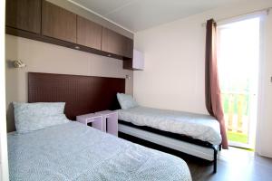 a bedroom with two beds and a window at Lodges camp in Setúbal
