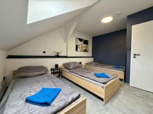 two beds in a room with blue towels on them at Teplice apartments DELUXE in Teplice