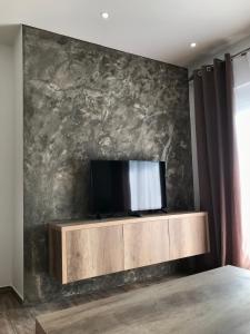 a bedroom with a tv on a wall at Apartments Suljovic in Ulcinj