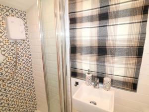 a bathroom with a sink and a shower at Lake View Shepherds Hut in Lincoln