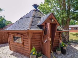 a large wooden dog house with a roof at Lake View Shepherds Hut in Lincoln