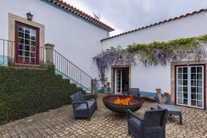 a patio with a fire pit in front of a house at 139 e 140 Casa dos Carvalhos in Castelo Branco