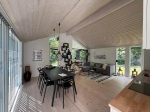 a dining room and living room with a table and chairs at Modern And Stylish Summer Cabin in Vejby +13 photos