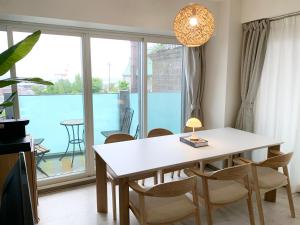 a dining room with a table and chairs and a balcony at O2 capsule house OTARU in Otaru