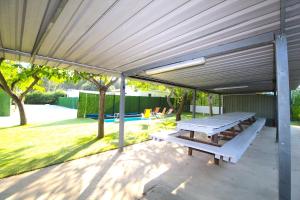 a patio with a picnic table under a canopy at Lodges camp in Setúbal