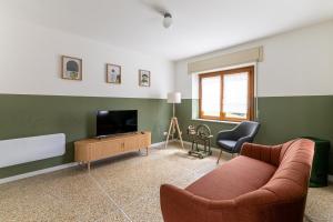 a living room with a couch and a television at Casa di Angelina in Avaglio