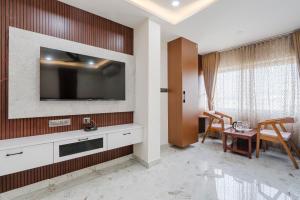 a living room with a television on a wall at Hotel Rasballa Grand in Bhadrāchalam Road