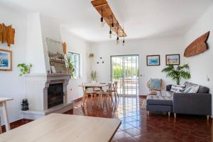 a living room with a fireplace and a table at Casa Codebò - Guest House in Aljezur