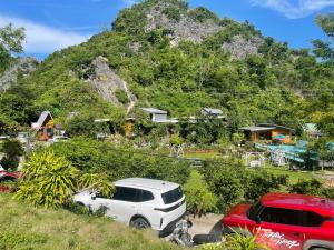 a white car parked in front of a mountain at Cat Ba Love House in Cat Ba